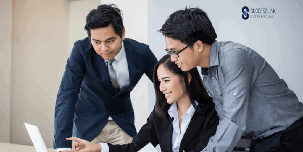 eam of professionals collaborating on a laptop, representing Business Process Outsourcing solutions for UK SMEs to boost efficiency and growth.